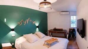 A bedroom with a bed, bedside table, and a desk. - A Getaway in the Pyrenees: Views, Hot Tub, and Forest (Marseillan)