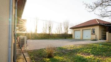 A building with a garage, a small garden, and a clear sky.