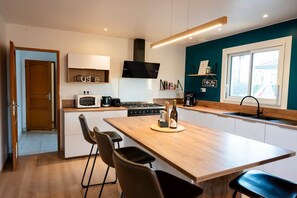 A modern kitchen with a central island, built-in appliances, and a view of the outdoors.