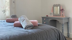 A bedroom with a bed, a dresser, a mirror, and a window with curtains. - Serene 3-bedroom cottage in lovely Pocklington perfect for relaxing (Pocklington)
