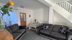 A modern living room with grey sofas, a wooden coffee table, and a staircase. - Serene 3-bedroom cottage in lovely Pocklington perfect for relaxing (Pocklington)
