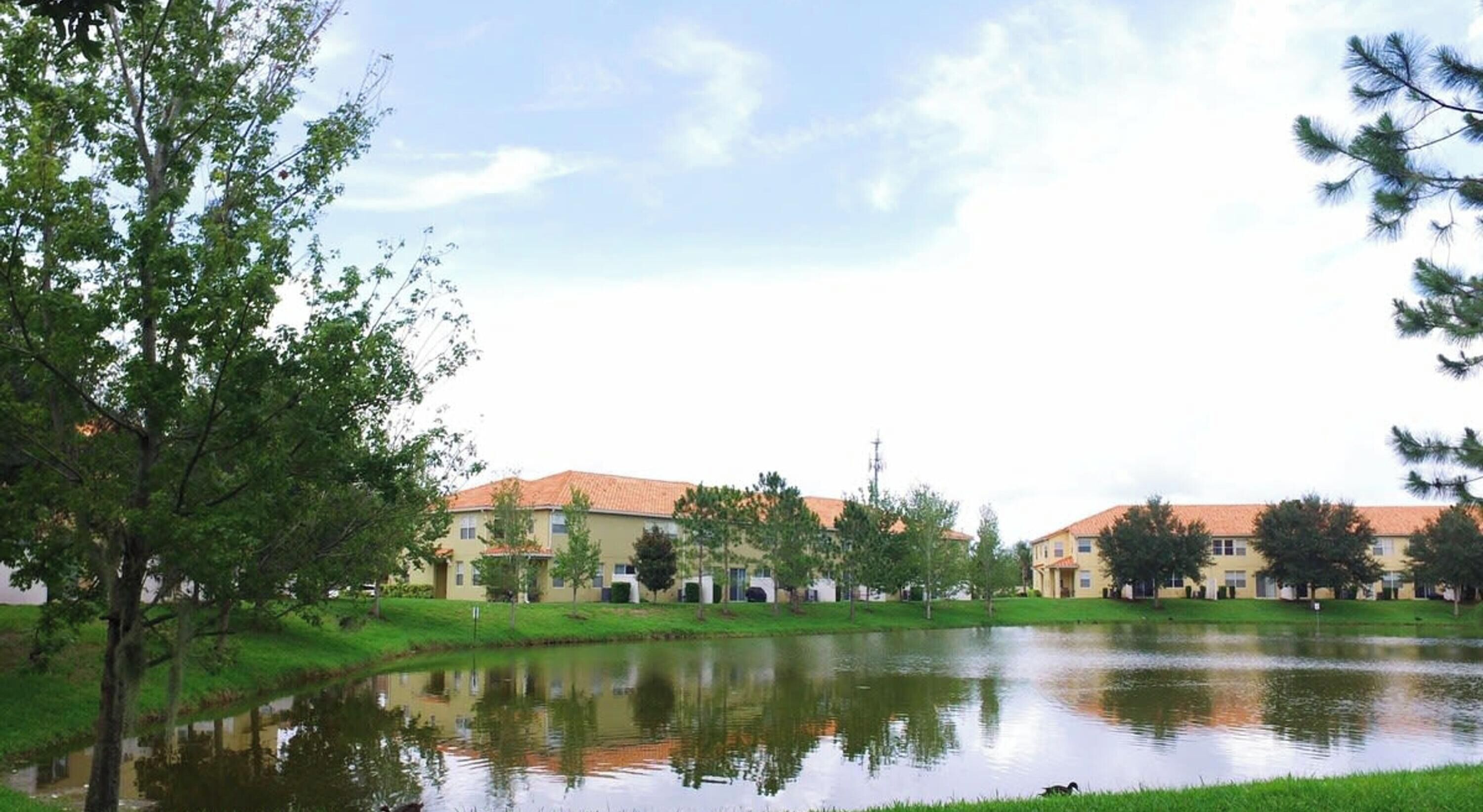 Una zona residencial con casas, un estanque y árboles.