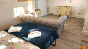 A bedroom with a bed, a dresser, a television mounted on the wall, and a door. - Luxurious studio room in the heart of East Kilbride 10mins from a hospital (East Kilbride)