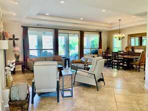 A spacious living room with a sofa, chairs, a dining table, and a chandelier. - Elegant Quail Creek Resort Home with Spool, in Green Valley near Tucson (Green Valley)