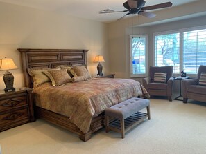 A bedroom with a large bed, two nightstands, a bench, a chair, and a ceiling fan. - AVAIL SEP 10 - OCT 5! Elegant Quail Creek Resort Home with Spool, Green Valley (Green Valley)