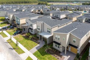 A residential area with modern houses, a paved driveway, and a visible street. - Gorgeous 5Bd Single Family w  Pool   Storey Lake 2767O (Kissimmee)