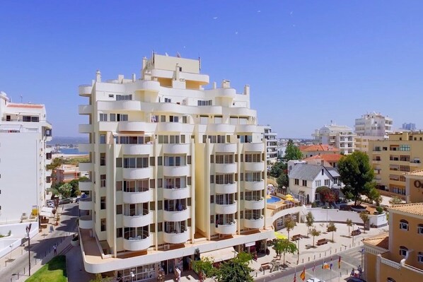 A multi-story hotel with balconies, a central courtyard, and a view of the sea. - Turim Algarve Mor Apartamentos (Portimão)