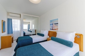 A hotel room with two beds, a desk, and a mirror. - Turim Algarve Mor Apartamentos (Portimão)