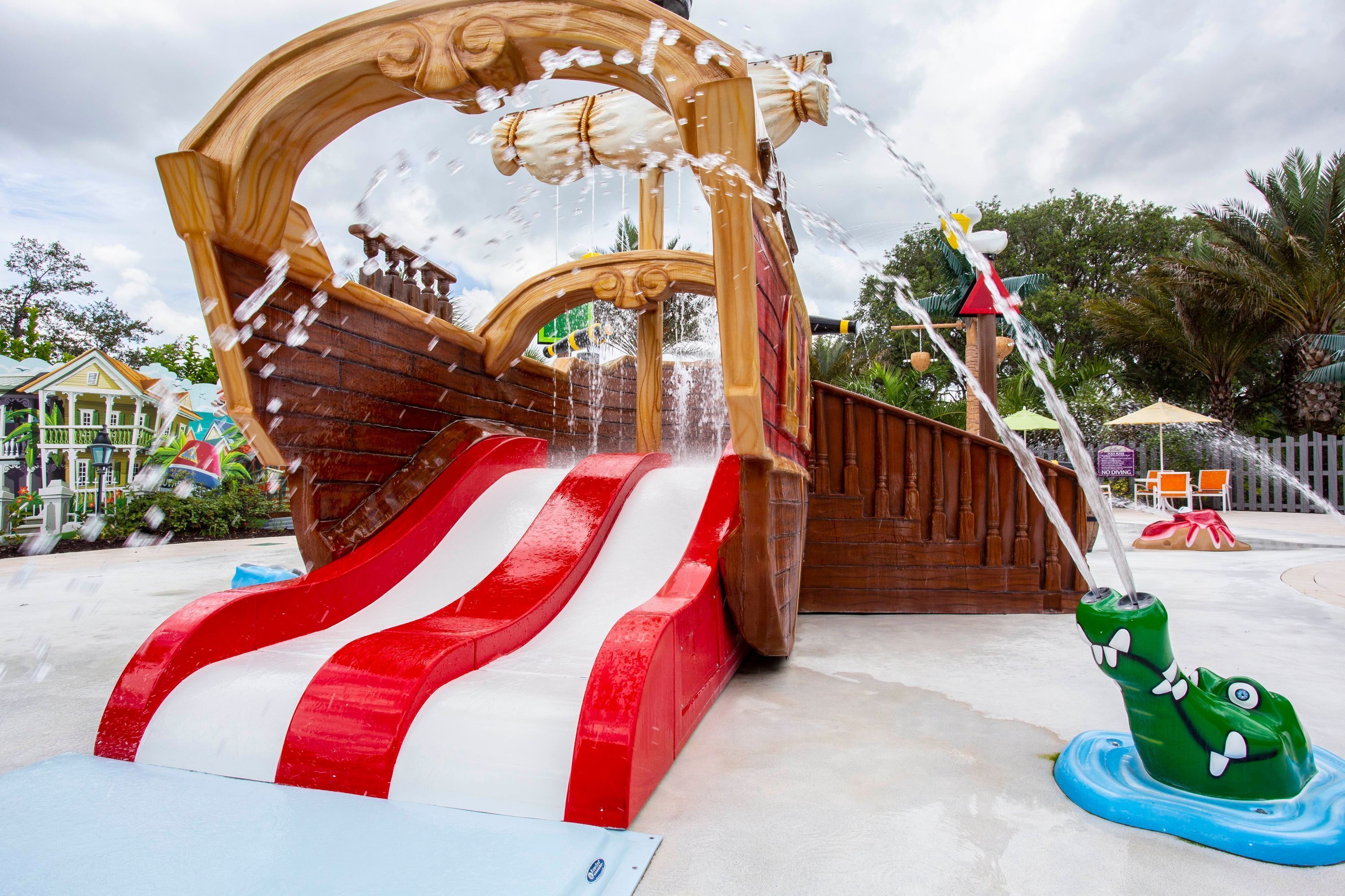 A water play area with a pirate ship slide and a water fountain.