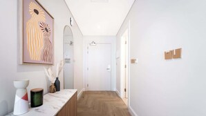 A hallway with a marble countertop, a wooden floor, and a large abstract painting. - StayShort - Stunning Studio in Business Bay that Sleeps 2! (Business Bay)
