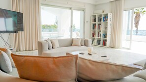Ein modernes Wohnzimmer mit einem weißen Sofa, einem Couchtisch und einem Bücherregal.