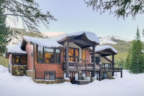 A multi-story lodge with a stone foundation, wooden exterior, and a balcony with a wooden railing. - Belemere Lodge in Blue River (Blue River)