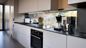 Una cocina moderna con una isla grande, horno empotrado y cafetera.