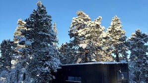 A snow-covered cabin with a number '3' sign, surrounded by tall, snow-laden trees. - Unique, Modern Cabin at Blefjell (Flesberg)