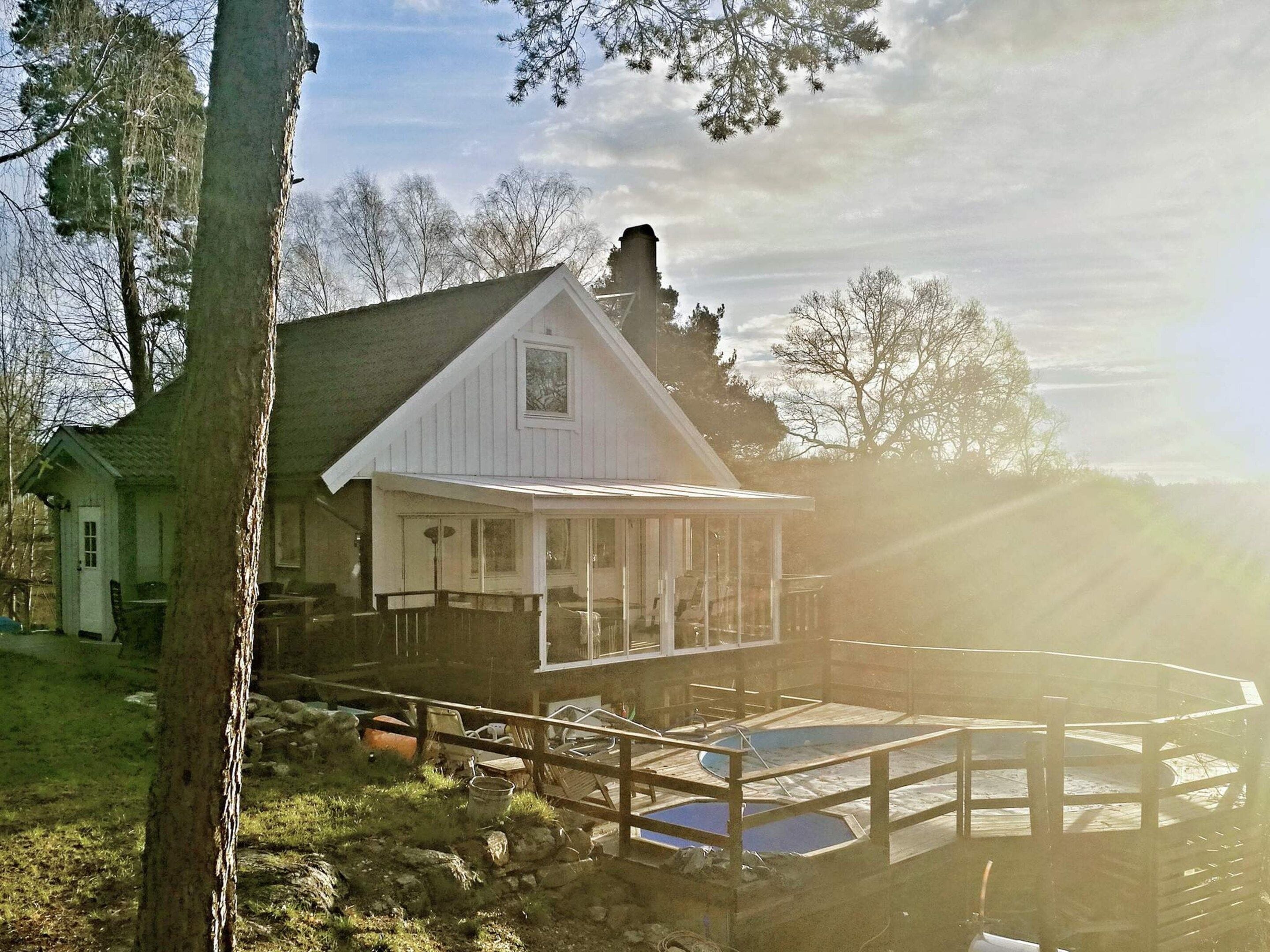 A house with a covered porch and a swimming pool.