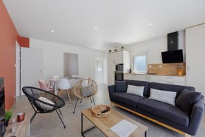 Ett modernt vardagsrum med en soffa, ett soffbord och stolar.