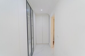 A hallway with a glass door, a white door, and a light switch on the wall. - Villa Punique: Villa exceptionnelle avec vue mer (Site archéologique de Carthage)
