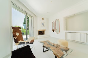 A modern living room with a glass coffee table, leather armchair, and a fireplace. - Villa Punique: Villa exceptionnelle avec vue mer (Site archéologique de Carthage)