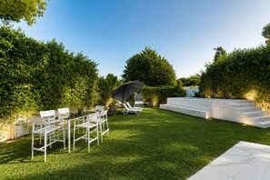 A well-maintained outdoor area with a pool, lounge chairs, and a dining set. - Villa Punique: Villa exceptionnelle avec vue mer (Site archéologique de Carthage)
