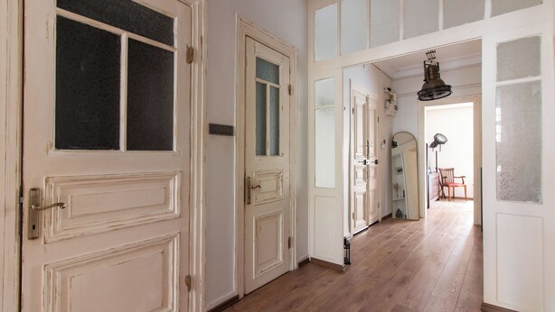 A hallway with wooden flooring and white doors with glass panels. - Historic & Cozy 2BR Nisantasi Flat w High Ceilings (İstanbul)