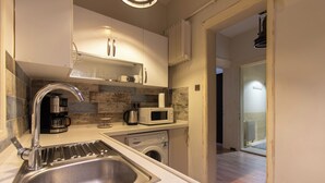 A modern kitchen with a stainless steel sink, a coffee maker, a microwave, and a washing machine. - Historic & Cozy 2BR Nisantasi Flat w High Ceilings (İstanbul)