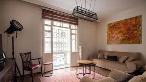 A living room with a sofa, chairs, a coffee table, a lamp, and a large abstract painting on the wall. - Historic & Cozy 2BR Nisantasi Flat w High Ceilings (İstanbul)