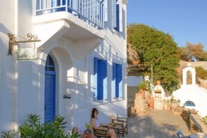 A white building with blue shutters and a balcony.