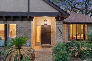 A house with a brick facade, a wooden door, and a number '130' on the wall. - Heater Pool! 10 beds-4 K beds, Games, Gym, Theater (San Antonio)