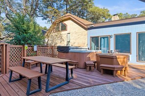 A wooden deck with picnic tables and a hot tub. - Heater Pool! 10 beds-4 K beds, Games, Gym, Theater (San Antonio)