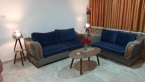 Una sala de estar con dos sofás, una mesa de centro y una lámpara.