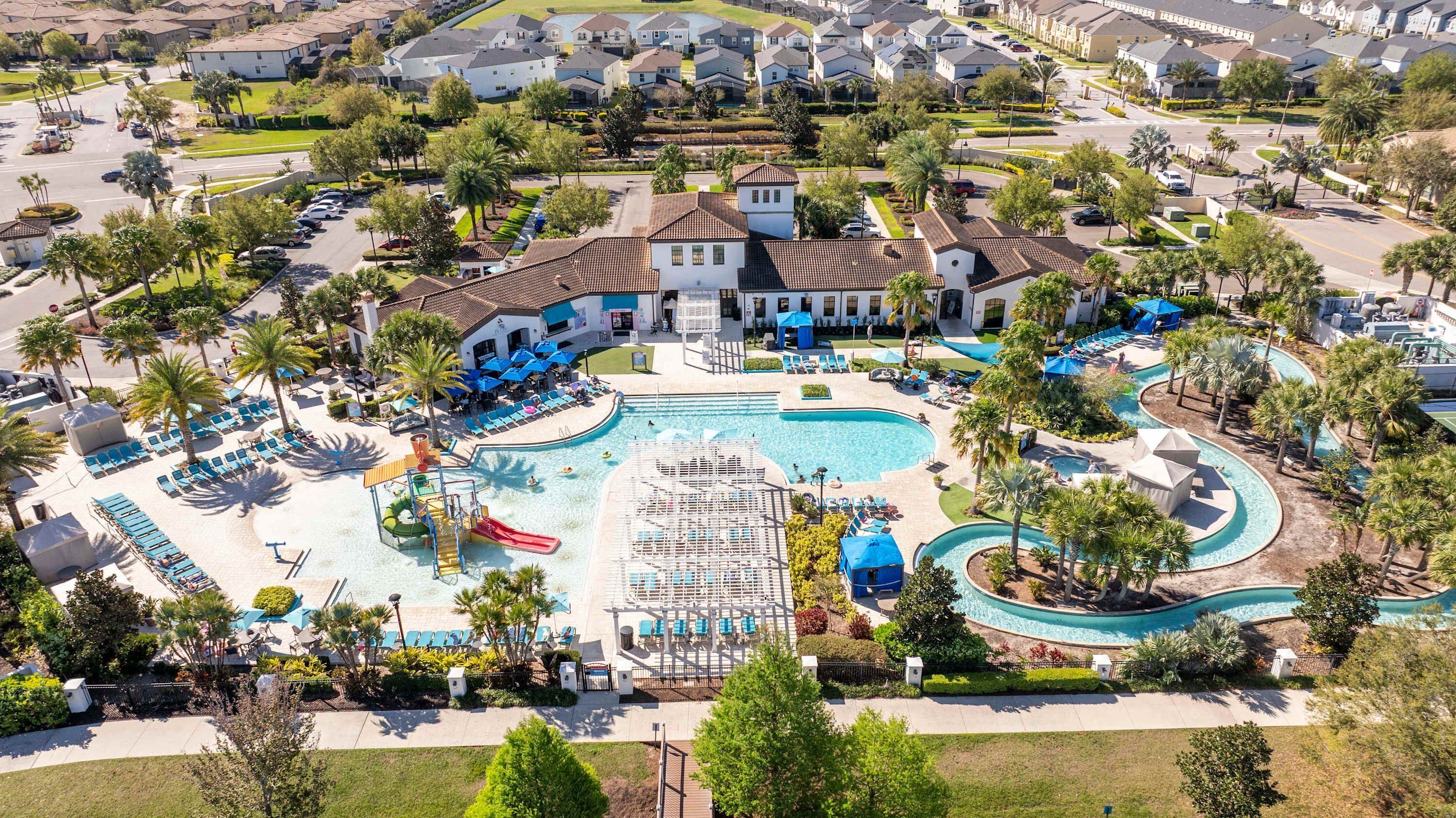 Een resort met een groot zwembad, meerdere glijbanen en ligbedden.