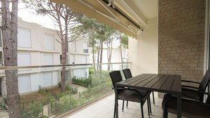 A balcony with a table and chairs, overlooking a garden and buildings. - SanPietro Vacation Apartment 023 (Plazhi San Pietro)