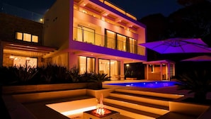 A modern two-story house with a swimming pool, outdoor lighting, and a fire pit. - SanPietro Elite Signature Villa (Plazhi San Pietro)