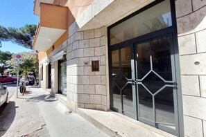 Ein Gebäude mit einer Steinfassade, großen Glasüren und blauem Himmel.