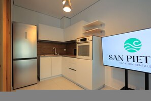 A modern kitchen with built-in appliances, a countertop, and a wall-mounted oven. - Cozy Getaway near the Beach (Plazhi San Pietro)