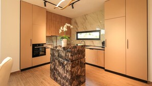 Een moderne keuken met een marmeren eiland, houten kastjes en een potorkidee.