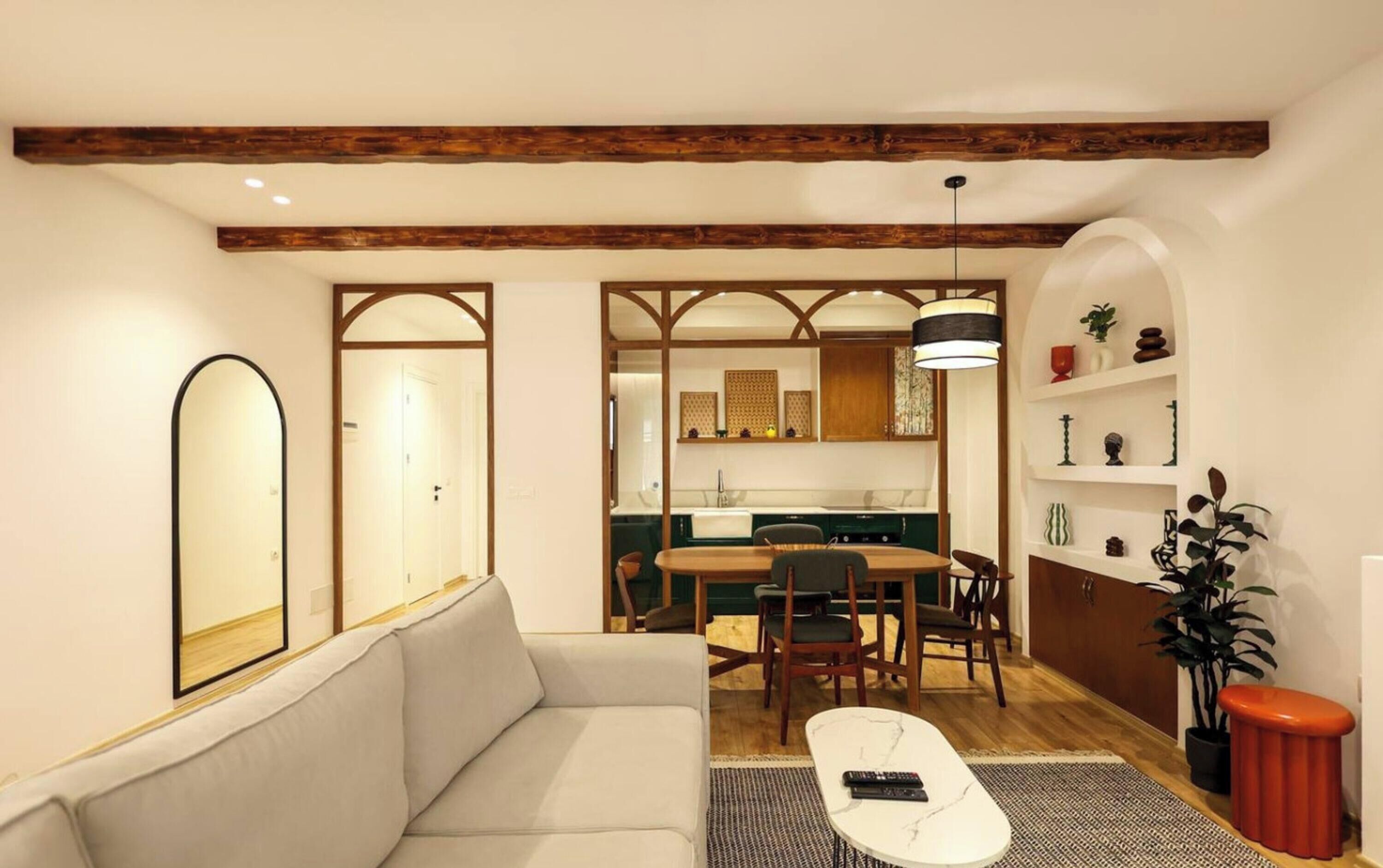 Una sala de estar moderna con un sofá, una mesa de centro y un comedor con sillas y una mesa.