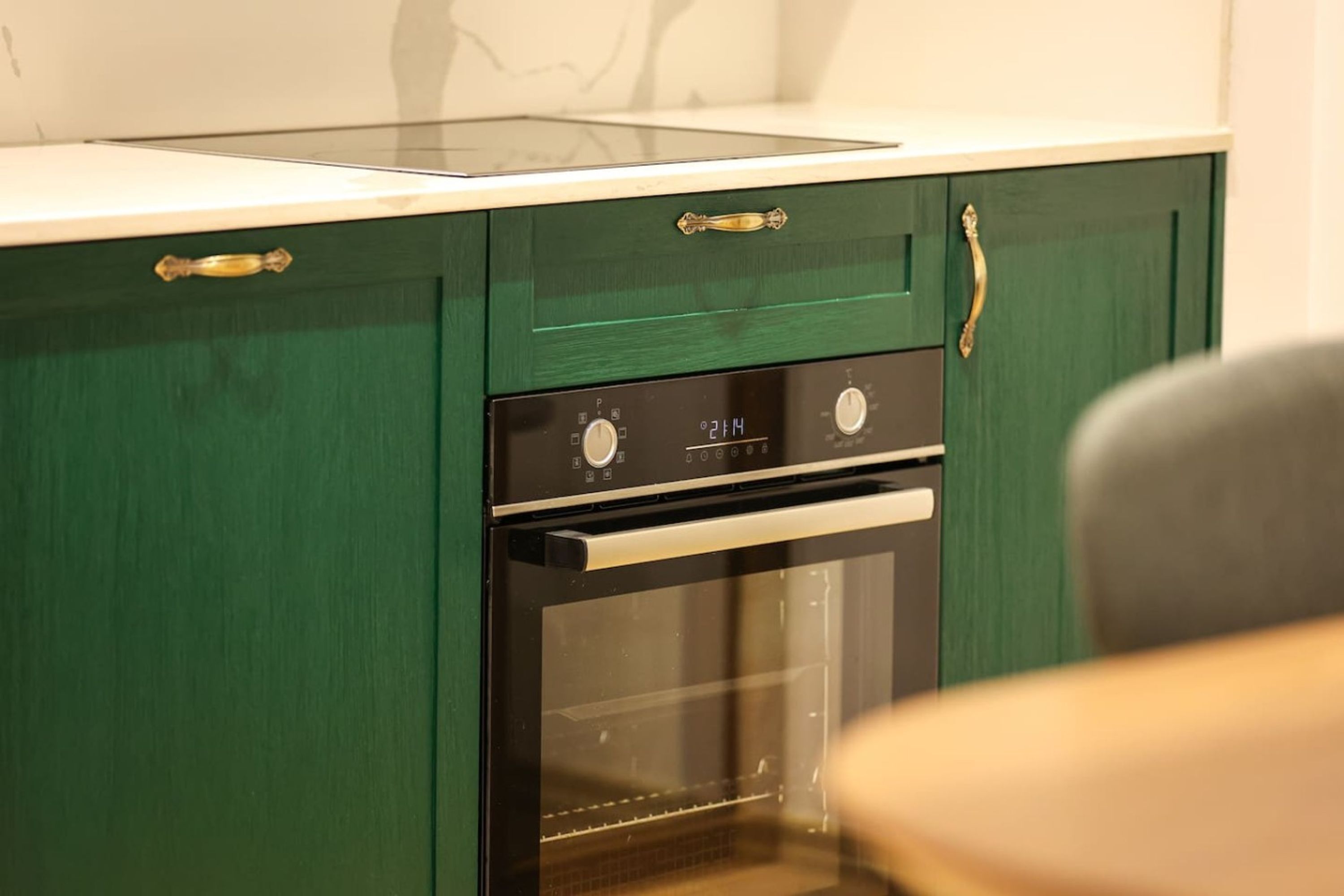 Een keuken met een ingebouwde oven en een wit aanrecht.