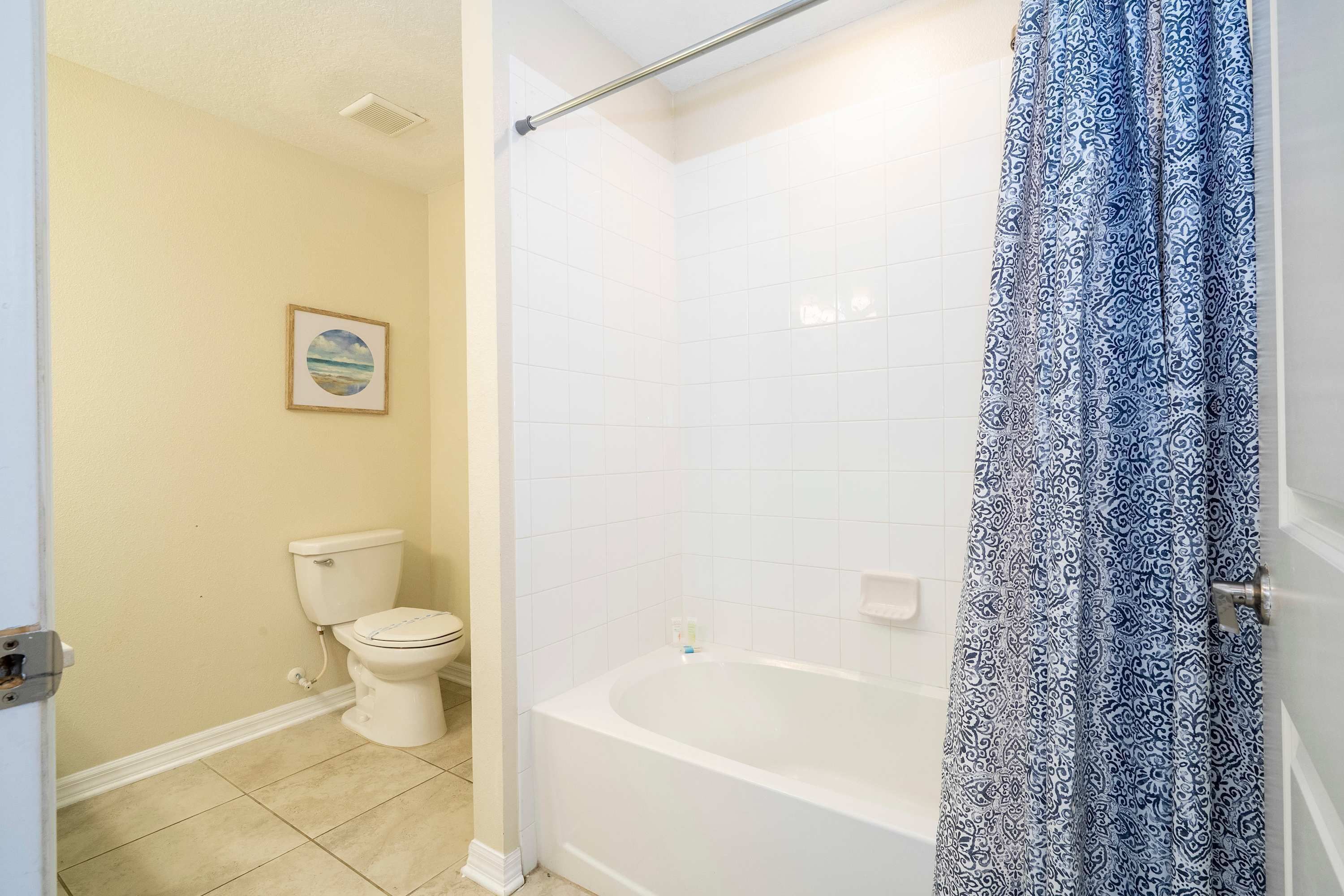 Un bagno con il water, una vasca e una tenda da doccia.