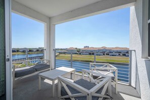 A balcony with a view of a water body and buildings. - Gorgeous 2Bd Close to Disney Storey Lake Resort 303 3121 (Kissimmee)