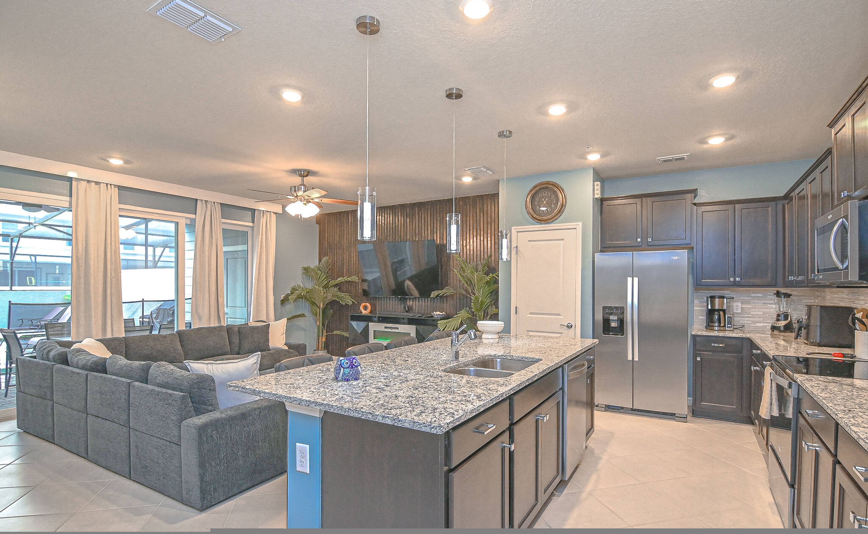 A modern kitchen with granite countertops, stainless steel appliances, and a built-in island.