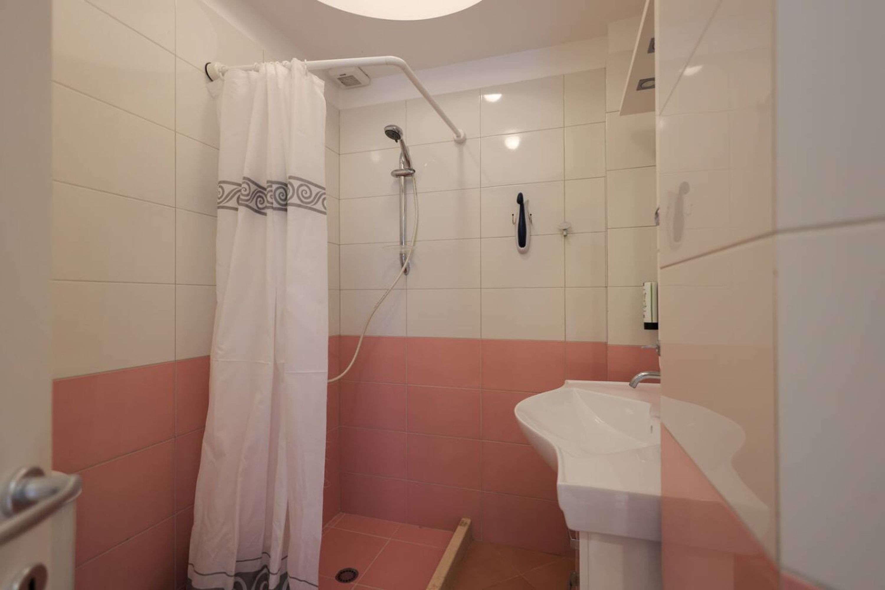 A bathroom with a shower, a sink, and a toilet.