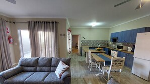 Una sala de estar con un sofá y un comedor con una mesa y sillas.