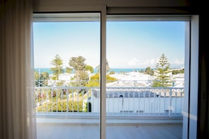 A balcony with a white railing, overlooking a coastal area with buildings and trees. - Villa Apollon:  Seaside and luxurious (Marsa)