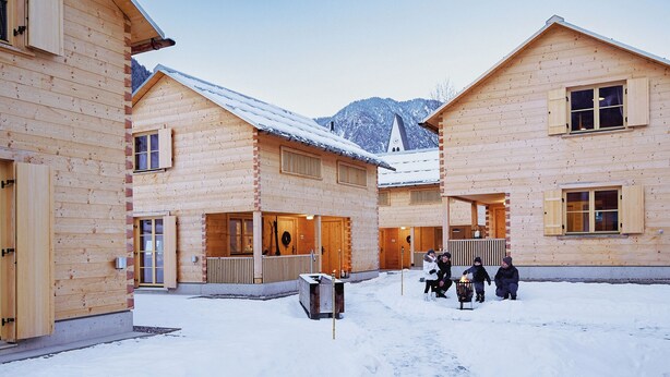 A wooden lodge with multiple rooms, a snow-covered ground, and a mountain in the background. - CASALPIN Chalets (Brand)