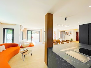 A modern hotel lobby with a seating area, a large black marble reception desk, and a view through the glass doors to the outside. - Villa Ambre : détente, piscine privée & hammam (La Marsa)