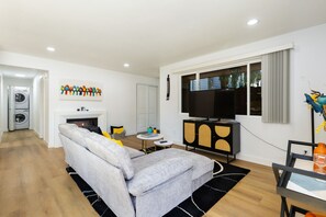 Una sala de estar moderna con un sofá gris, un televisor de pantalla plana y una chimenea.