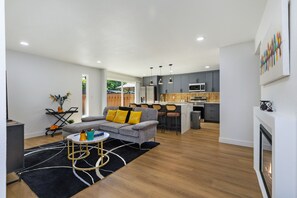 A modern living room with a grey sofa, a coffee table, and a fireplace.