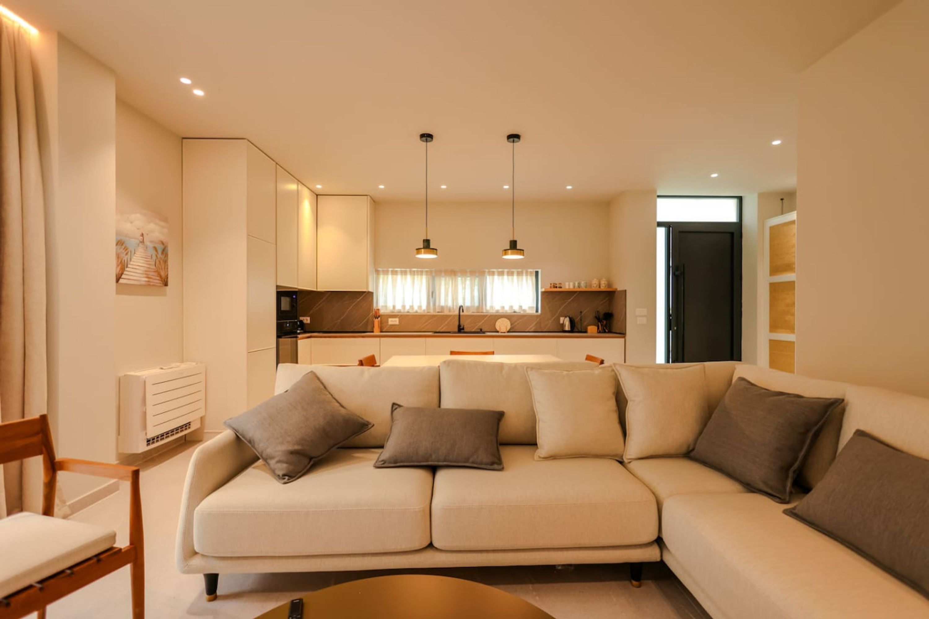 A modern living room with a sofa, a coffee table, and a dining area.
