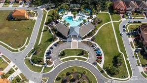 Oversigtsbillede af et boligområde med et centralt rundkørsel, en swimmingpool og omkringliggende huse.